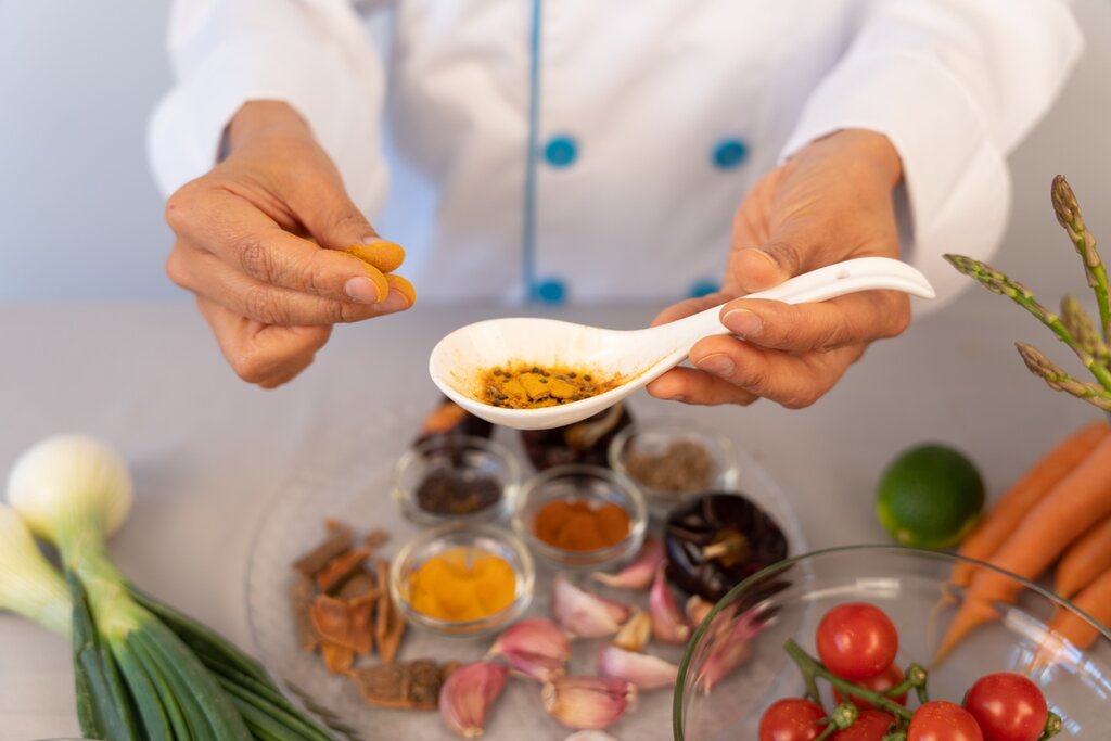 Chefs hands manipulating and observing the colors and textures of spices in the kitchen of her restaurant