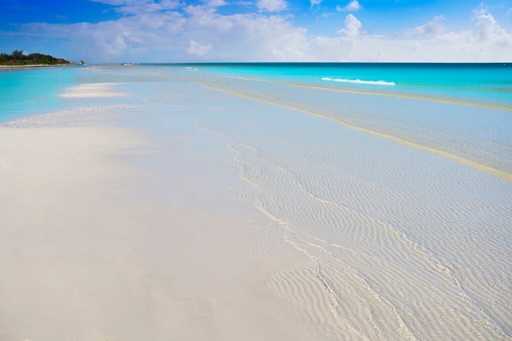 Shallow turquoise waters over white sand