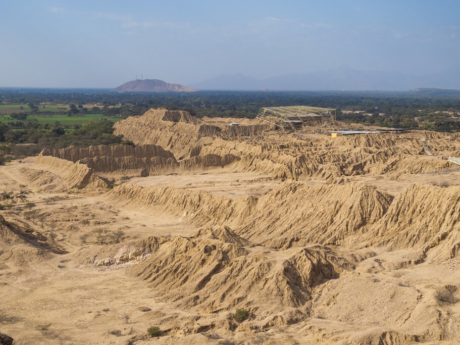 Aerial view of the Túcume Archaeological complex with green forest and mountains in the background