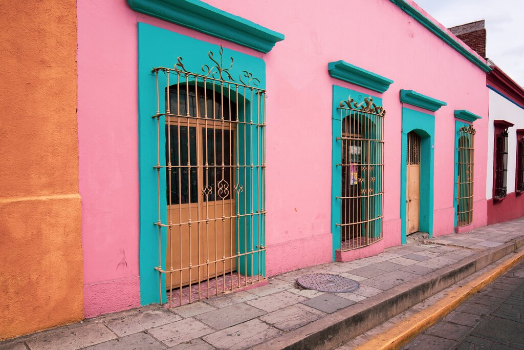 Bright pink building with blue shutters in colorful Oaxaca City
