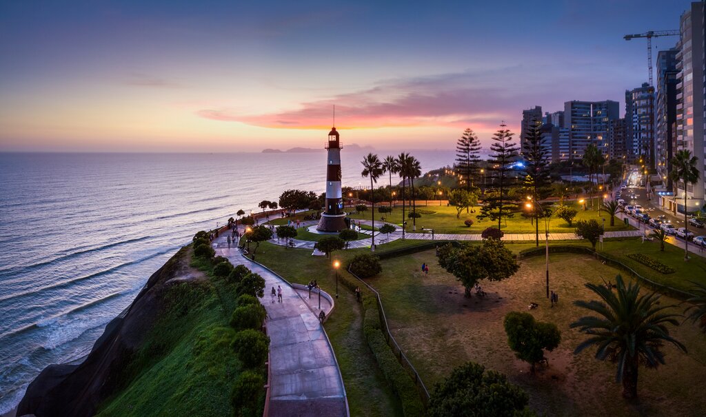Panoramic view of Miraflores coast at sunset with the ocean on the left and lighthouse center