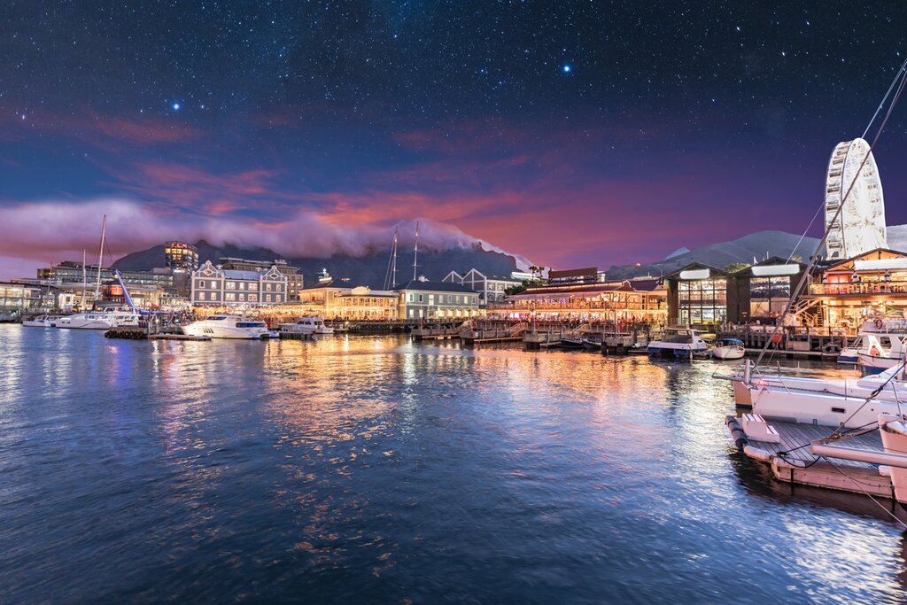 South Africa, waterfront Cape Town lit at night, purple evening sky