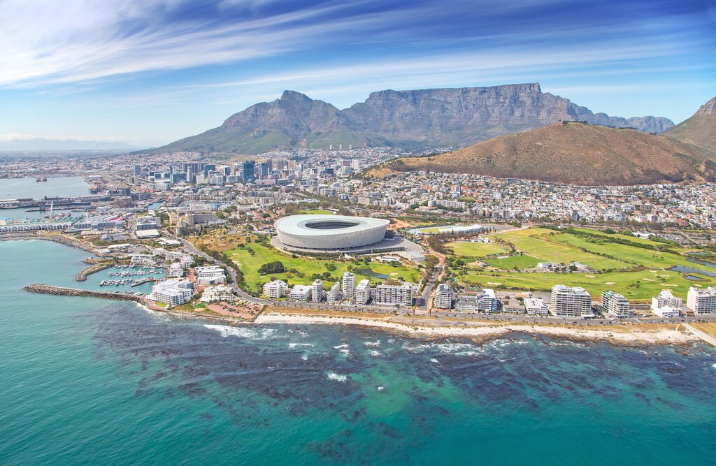 Aerial view of Cape Town during the day, with the stadium in the foreground and Table Mountain visible in the background