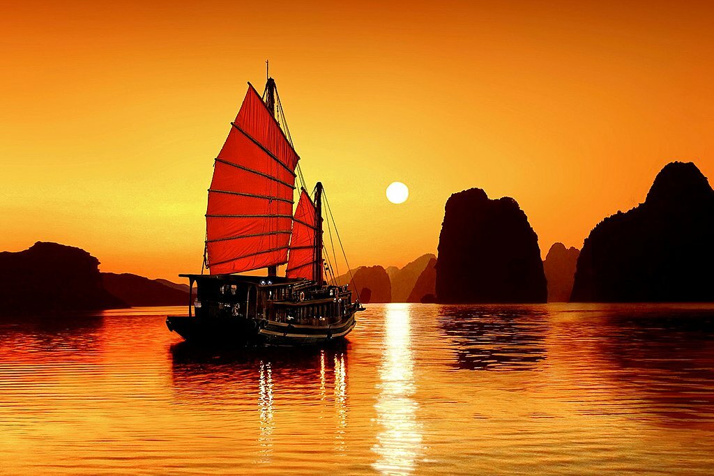 Boats sailing at sunset on Ha Long Bay