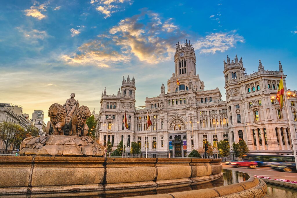 The city skyline and sunrise at Cibeles Fountain town square in Madrid