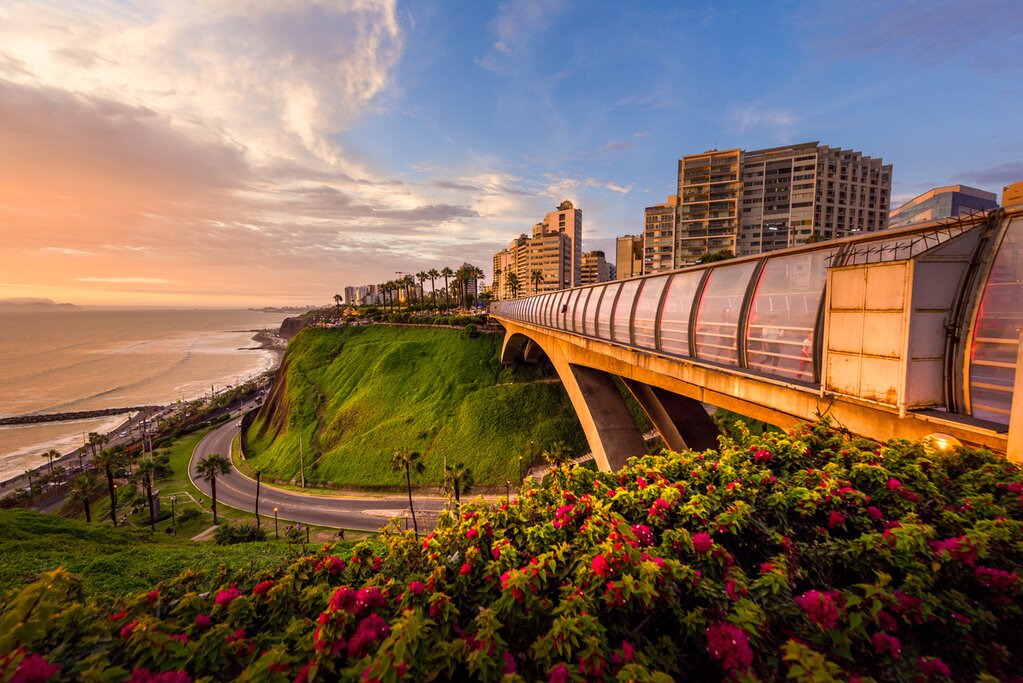 Villena bridge at sunset in Miraflores district in Lima, Peru. The bridge is on the right and the cliffs and ocean are on the left