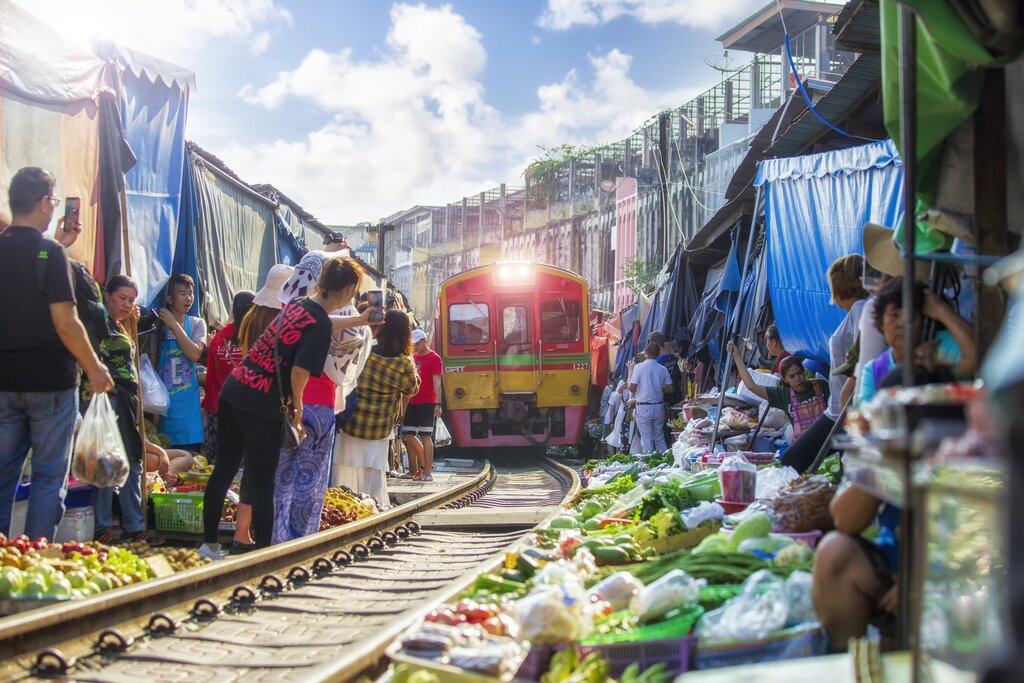 A train passing through a narrow street market in Bangkok