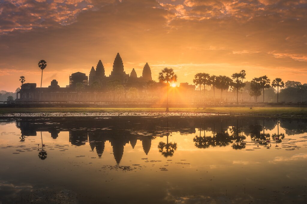 Photo of a golden sunrise over Angkor Wat with a reflection in the water