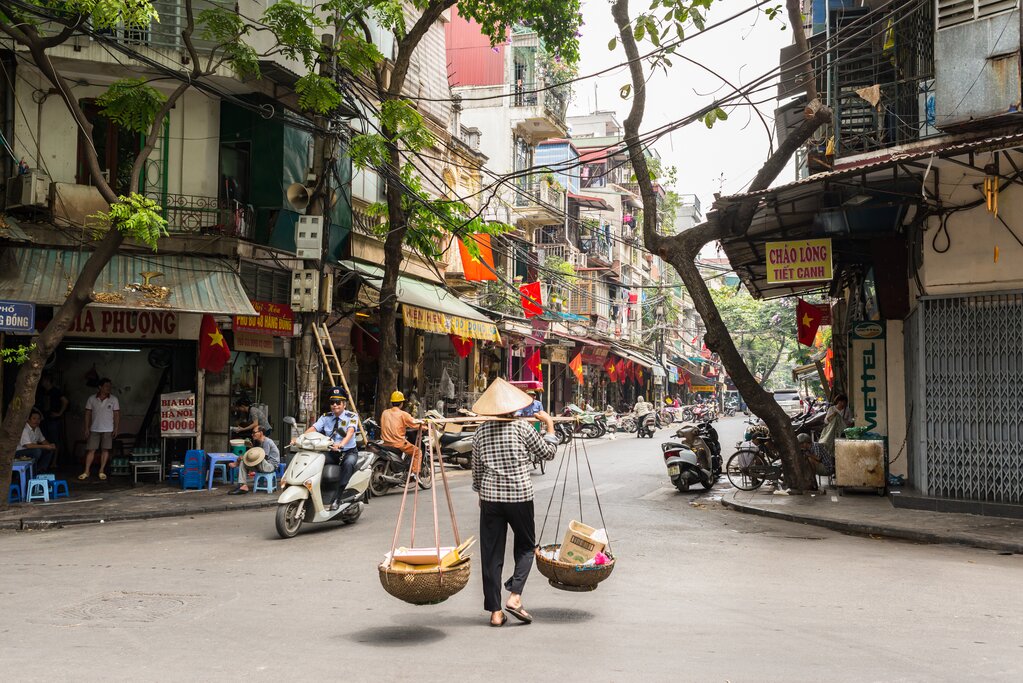 A street vendor carrying goods in Hanoi's Old Quarter