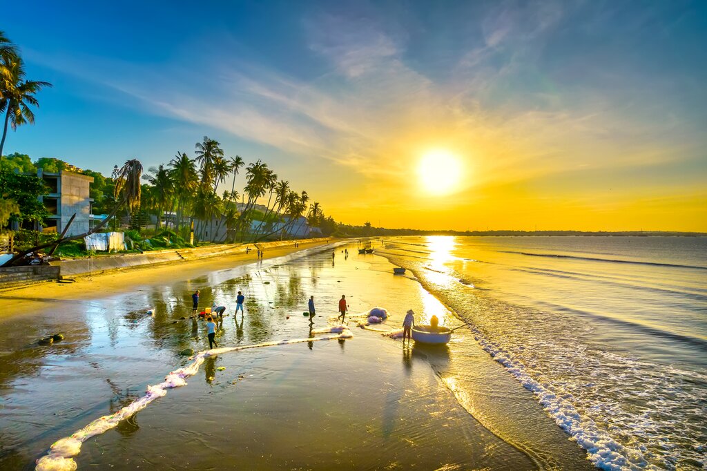 Dawn on the beach with tilted coconut trees