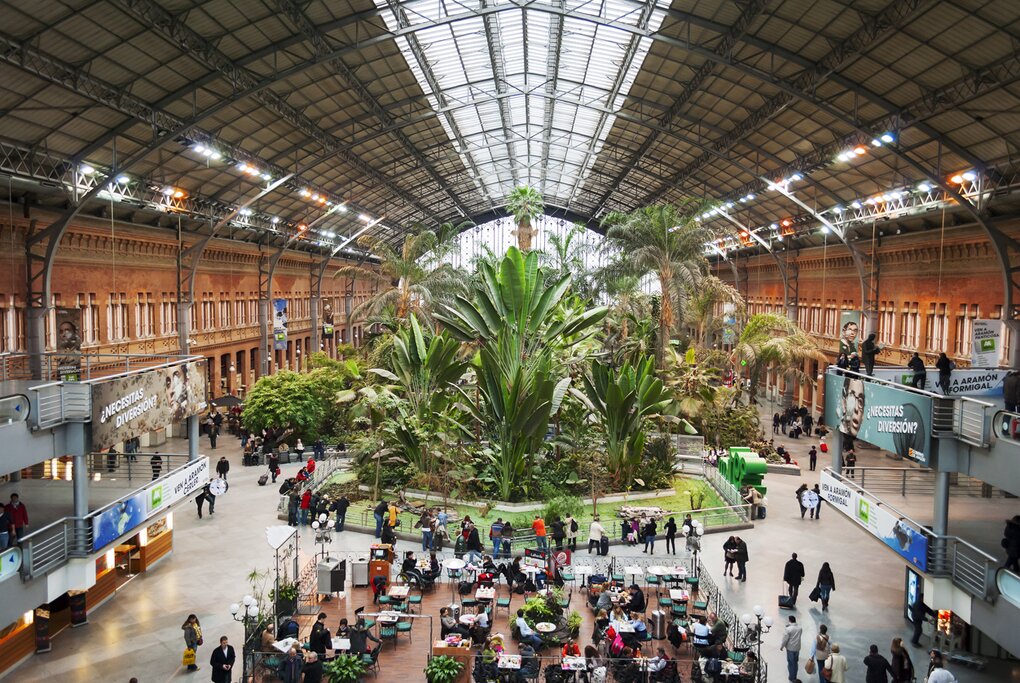 botanical garden and people sitting at the tables inside the atocha train station in Madrid